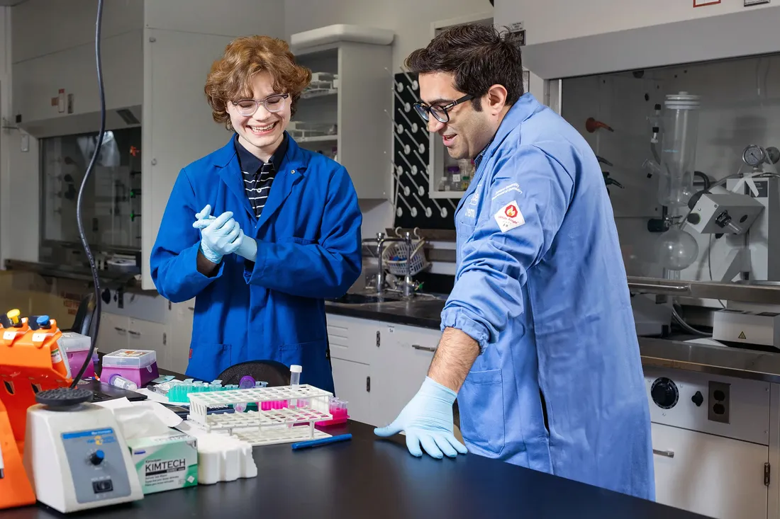 A student works in a laboratory with Professor Davoud Mozhdehi