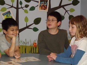 A group of children sitting around a table.