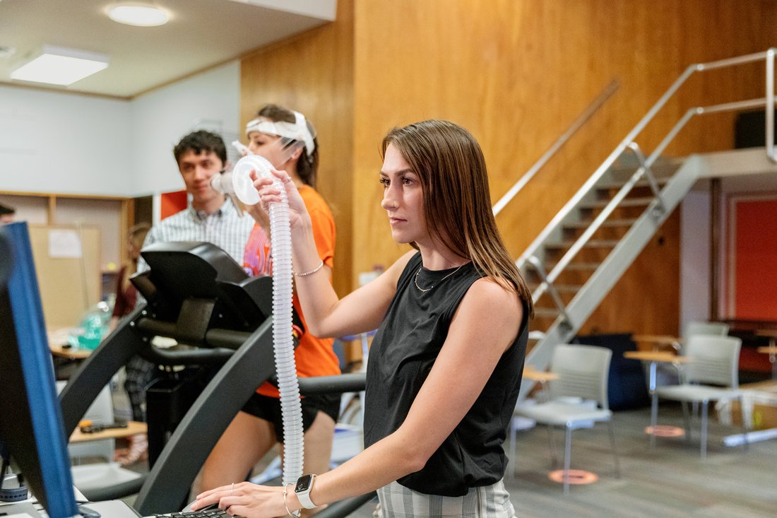 Student researchers take measurements while research subject is on a treadmill.