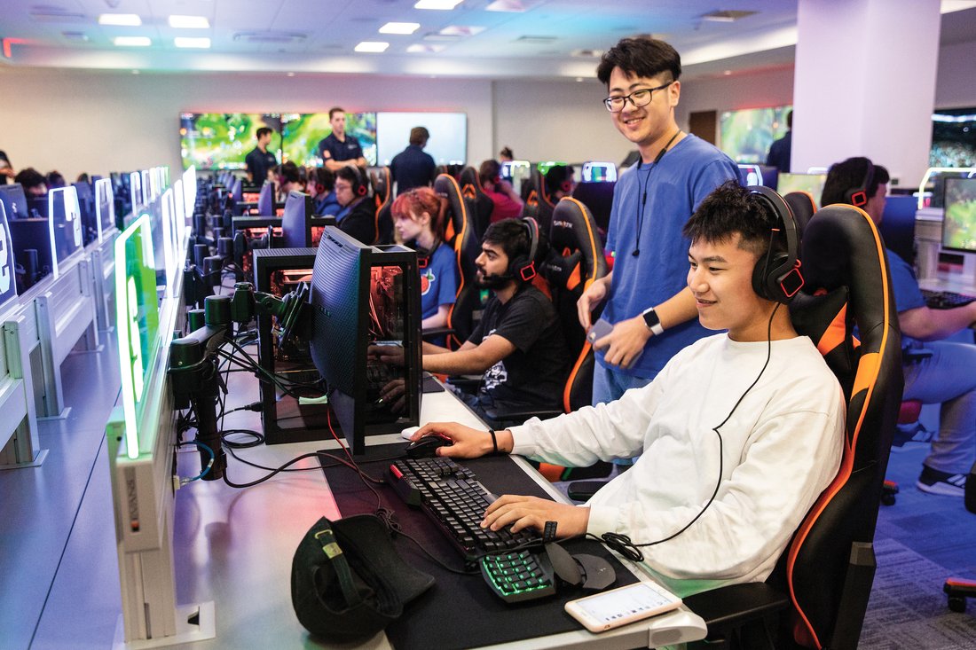 Students play esports in a large gaming room.