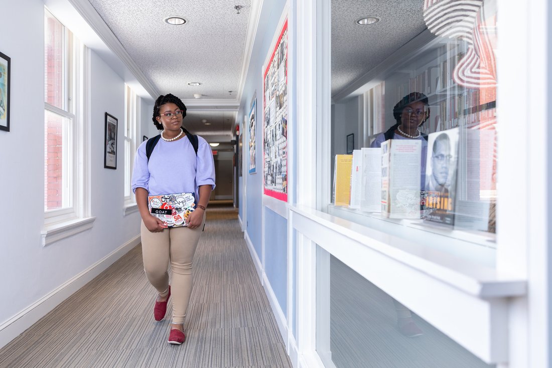 African American studies major Jazmine Richardson walks through the hallway of a Syracuse University building