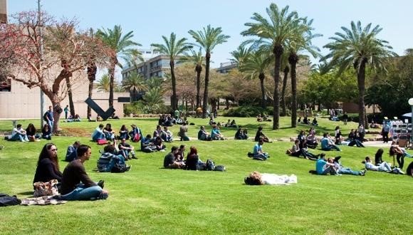 A group of people sitting on the grass.